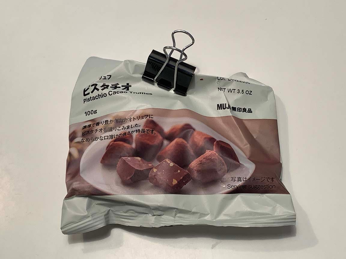 Muji Pistachio Cacao Truffles bag folded over at top and kept closed with a bulldog clip