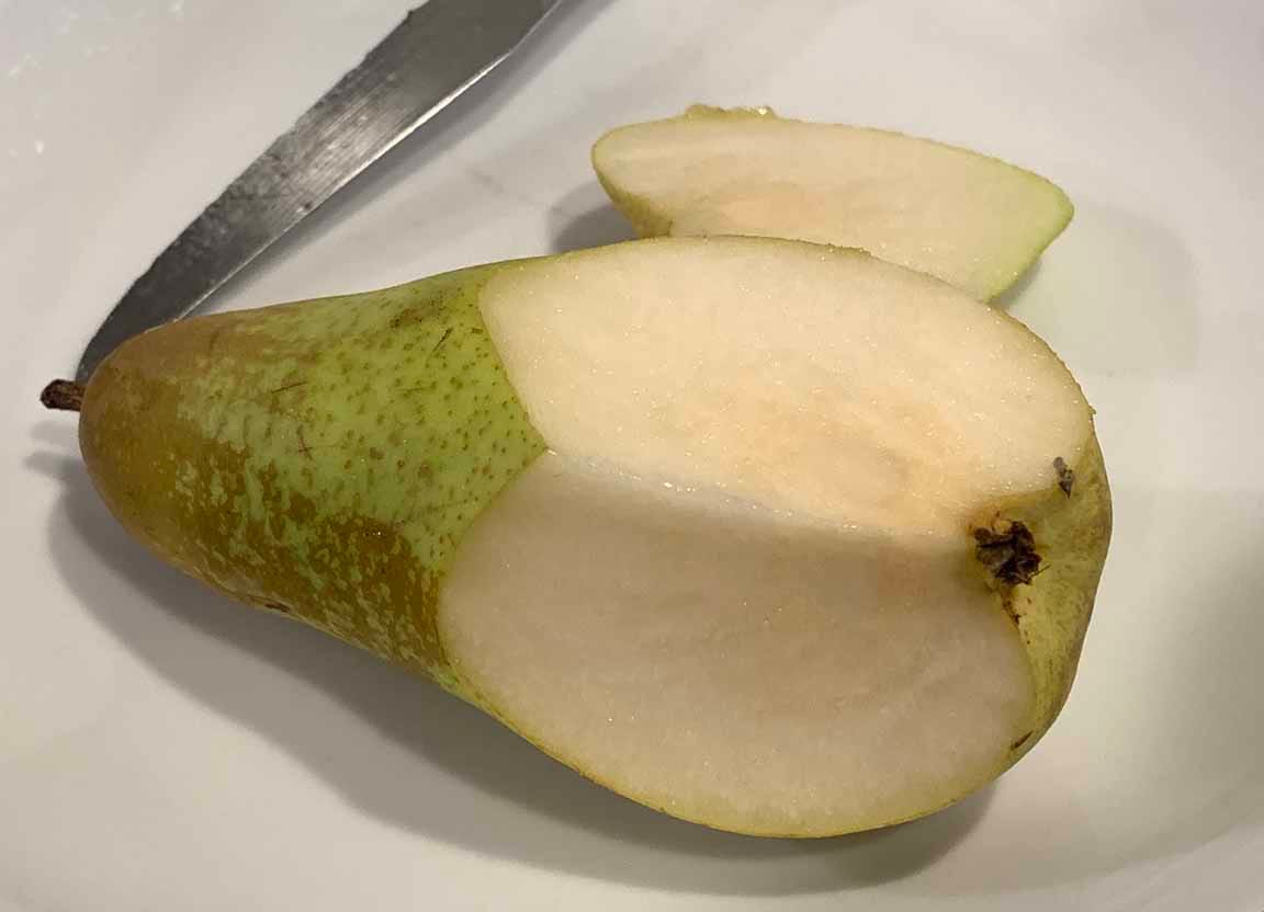 One of the pears sliced open revealing nice uniform fruit-flesh
