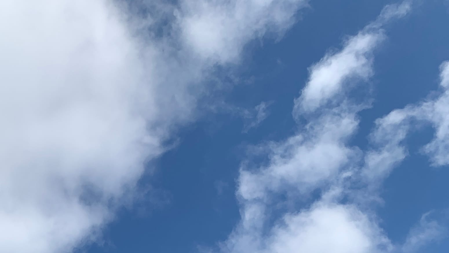 A sky that's about half wispy clouds and half blue