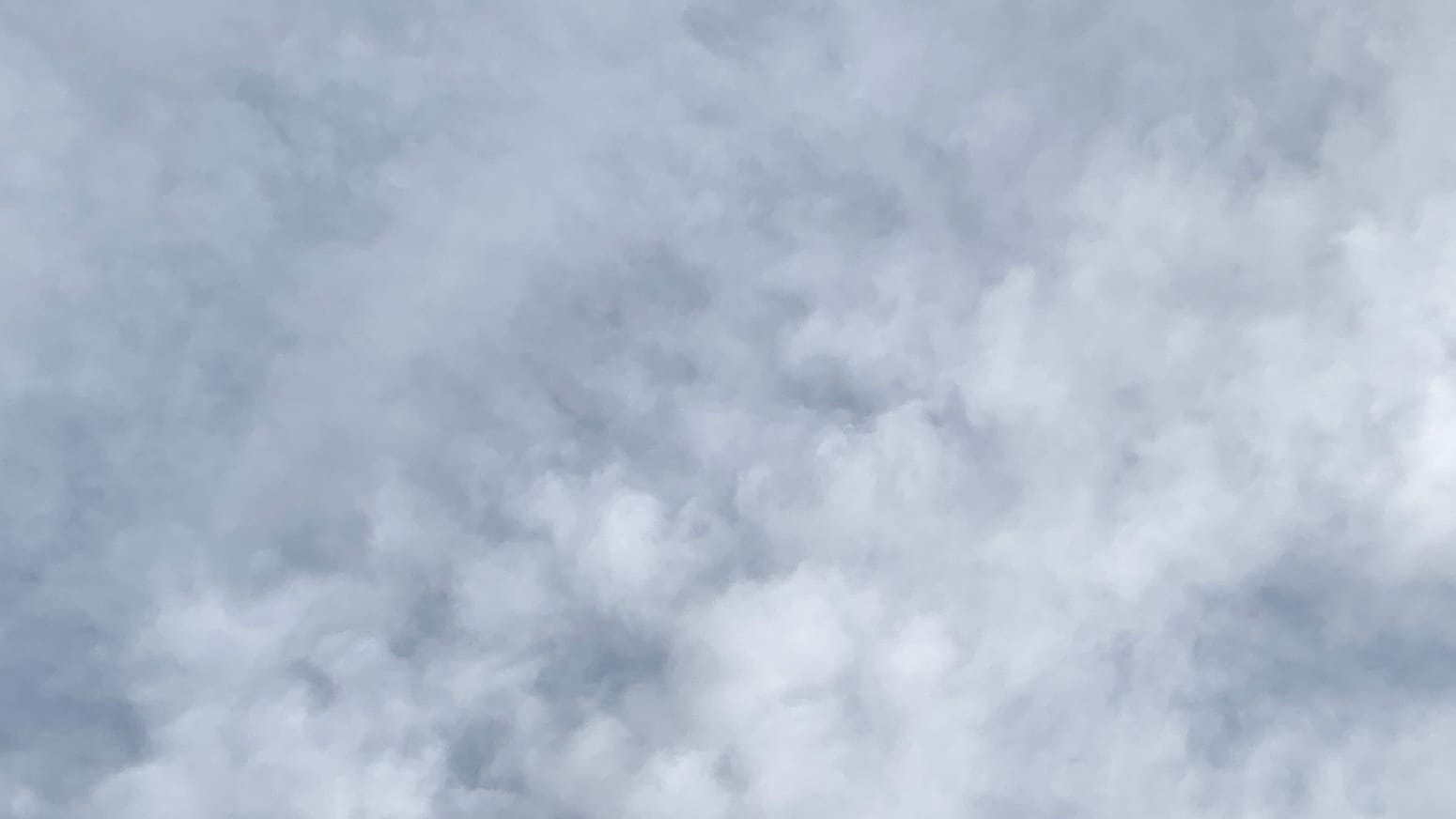 A sky of loose gray cloud, more clumped and dappled along the lower-left to upper-right diagonal