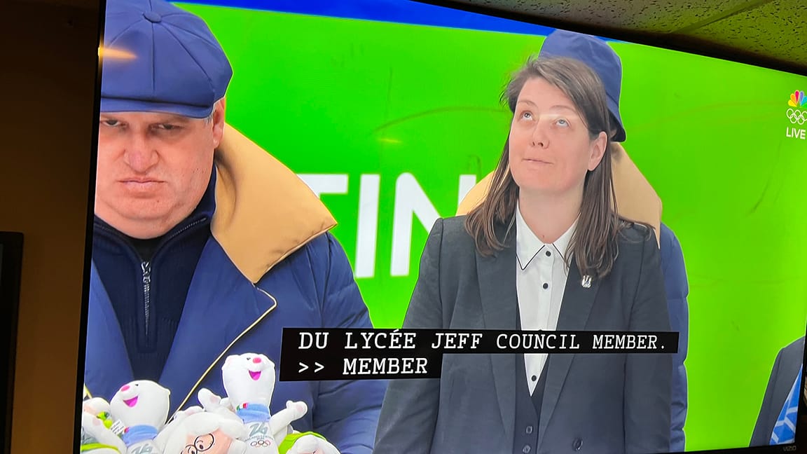 Guy at the hockey holding a box of plush toys given to the Olympians and he looks grumpy