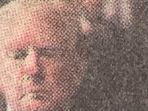Detail of a photo in print edition of the New York Times, containing an image of Donald Trump with eyes closed.