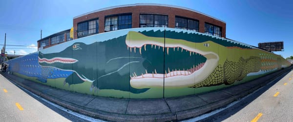 A mural with three alligators overlapping, green, dark green, and blue