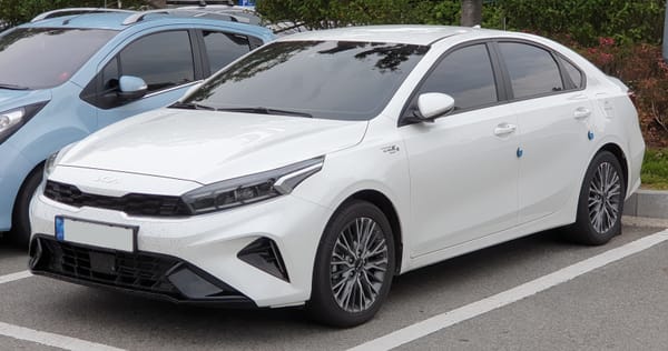 A "Kia K3 BD FL Snow White Pearl" in a parking lot