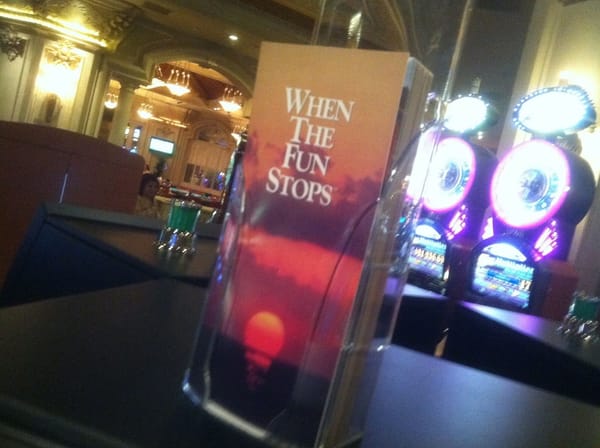 Container of brochures entitled WHEN THE FUN STOPS on a table in casino. Looks like a funeral parlor brochure